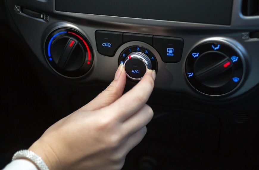 Woman turning on car air conditioning system