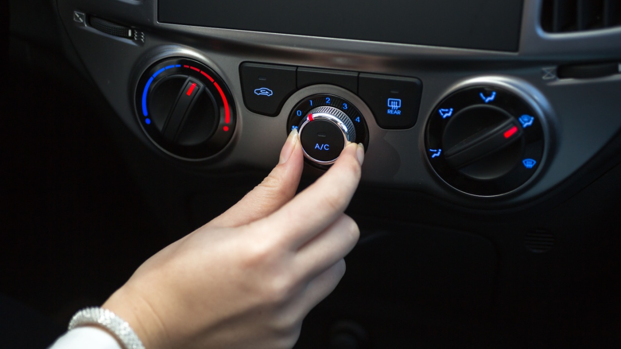 Woman turning on car air conditioning system