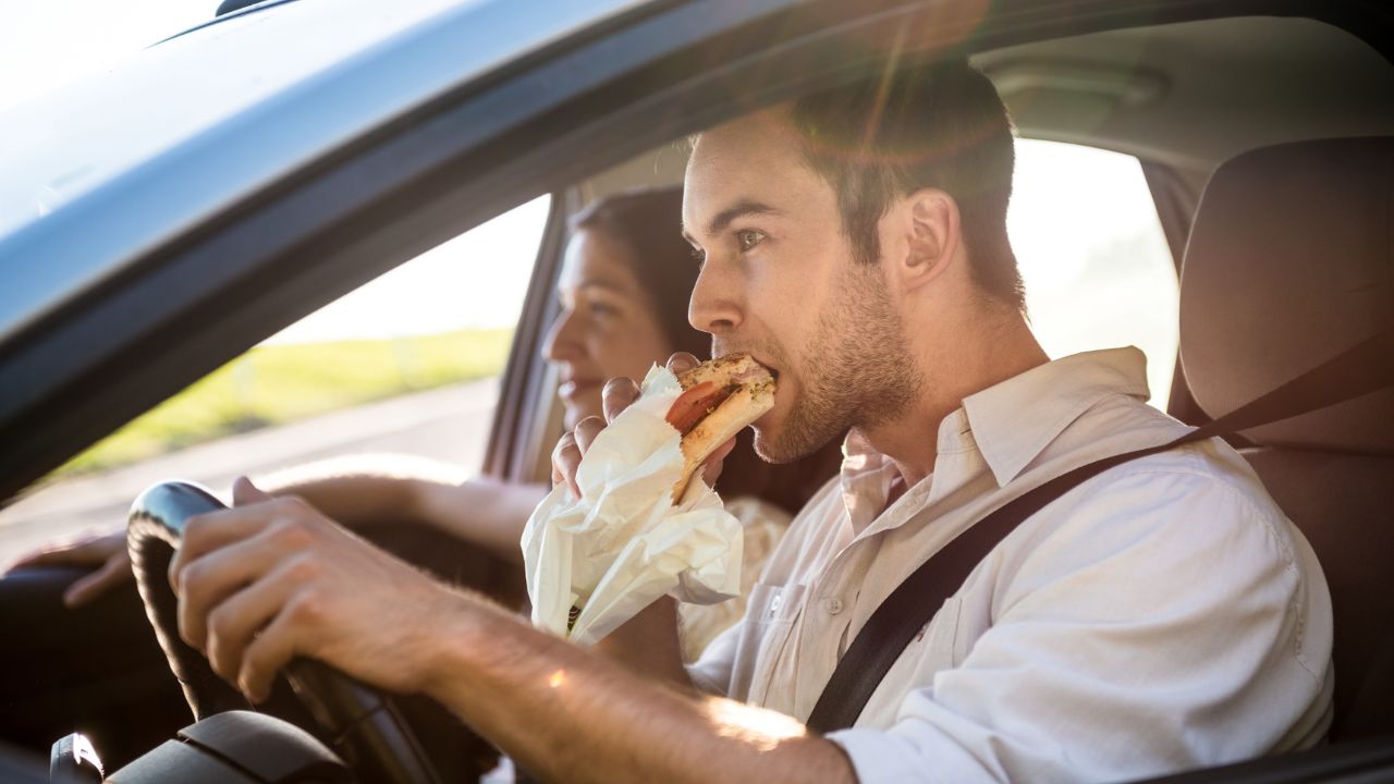 man eating in car