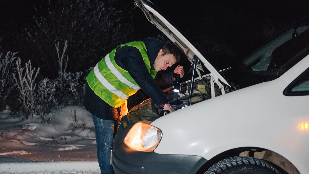man in reflective vest checking car engine
