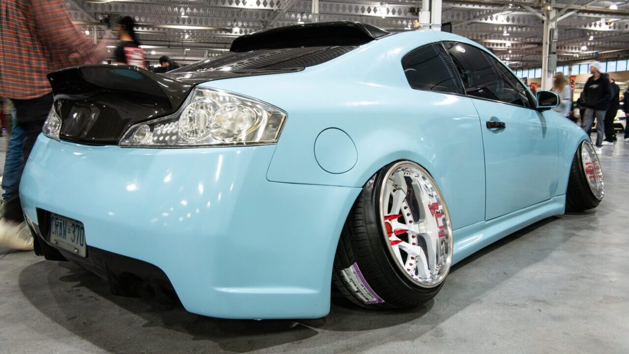 ight blue sportscar with custom parts and cambered wheels.