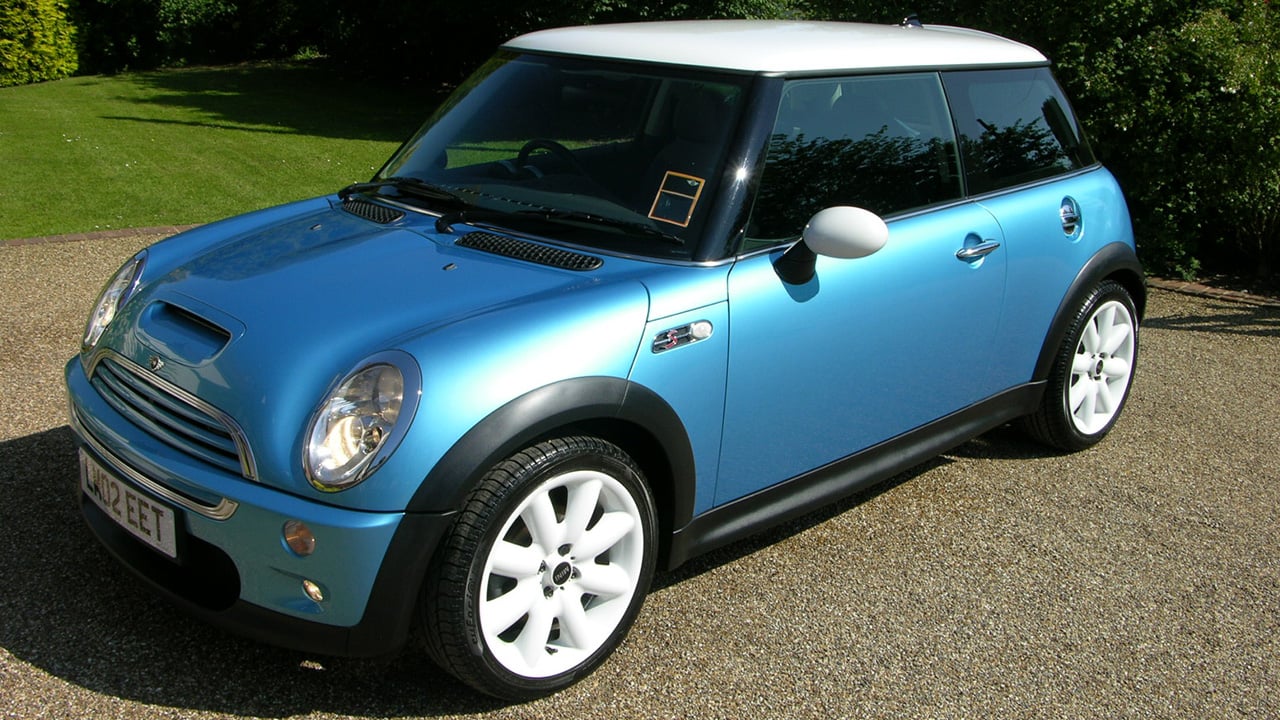 A blue R53 Mini Cooper S with white wheels and a white roof, front 3/4 view