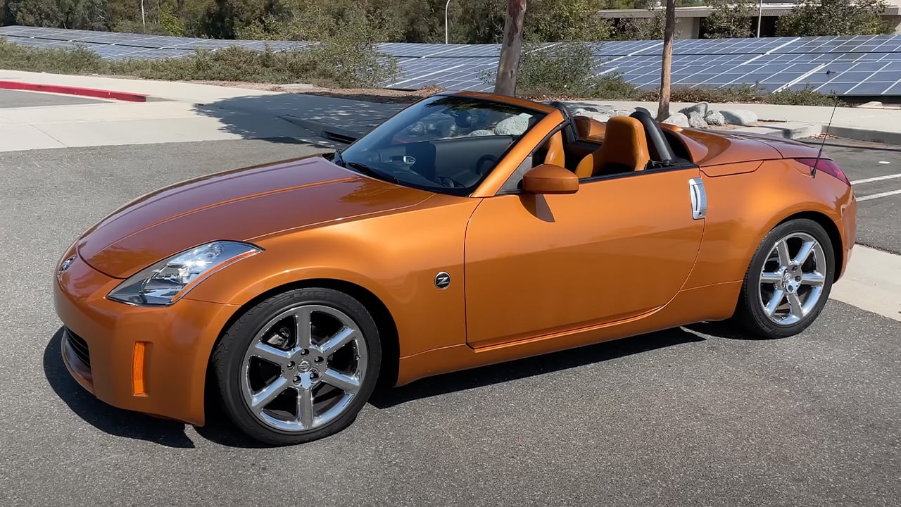 А Nissan 350Z Convertible in orange, front 3/4 view, roof down