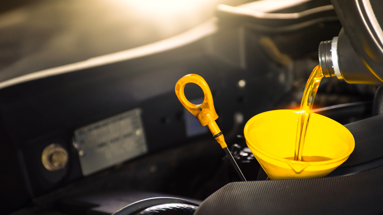 Car maintenance service , Pouring engine oil into a funnel for engine maintenance include a oil dipstick for oil level measurement , copy space , Car repair garage business concept