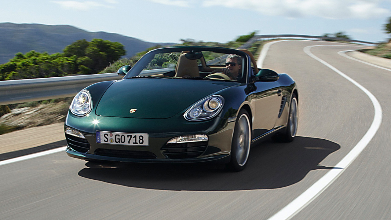 A green 987 Porsche Boxster on the move, front 3/4 view