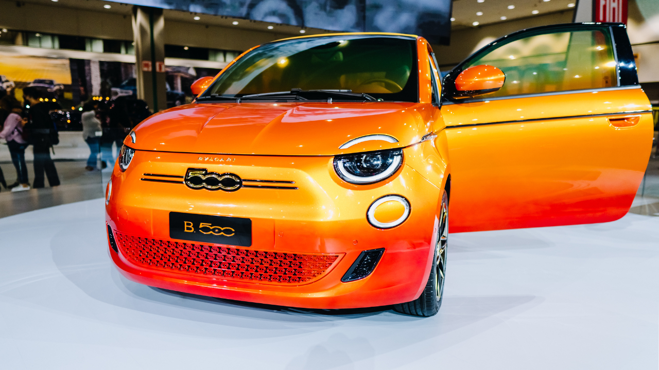 Bright orange FIAT 500e Bulgari EV, indoors in a showroom