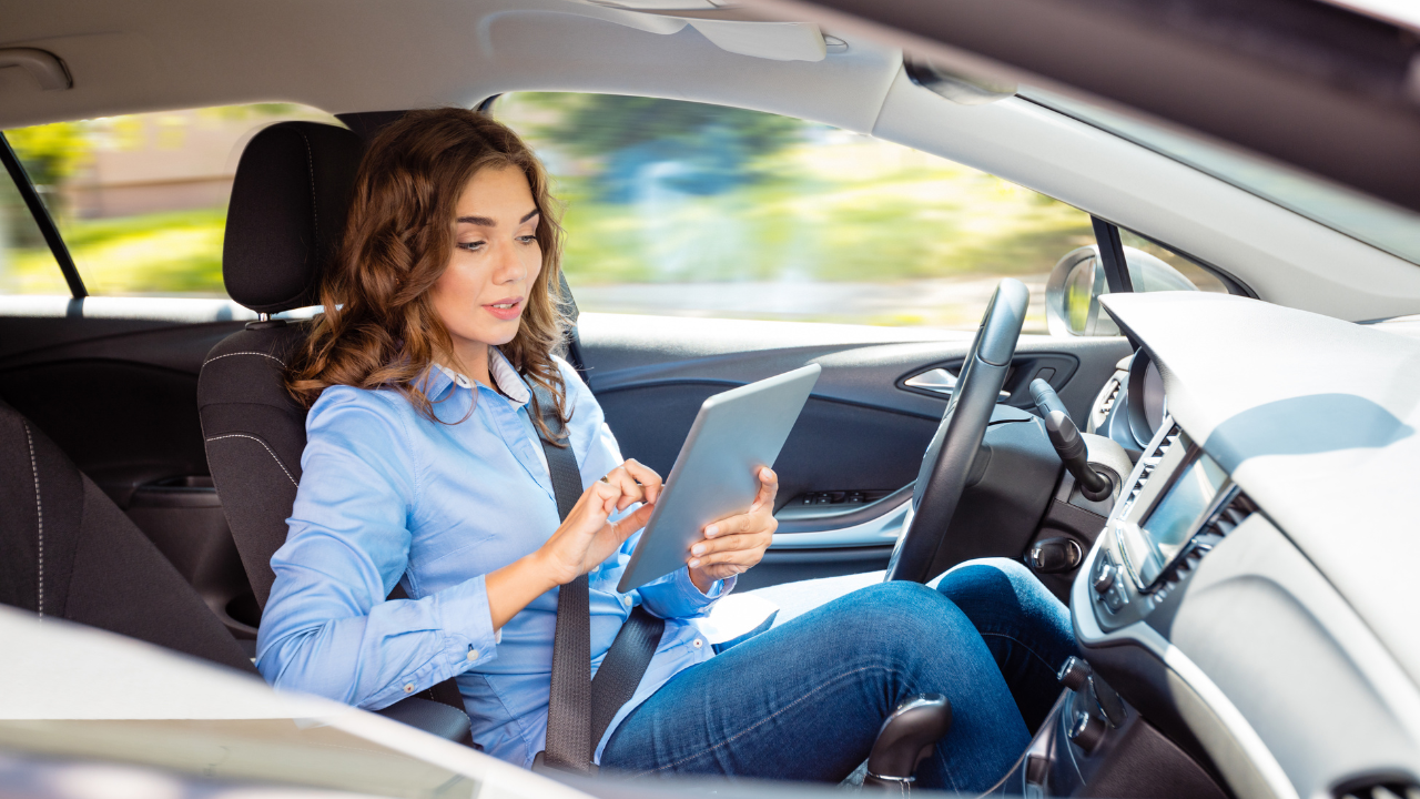 Woman on tablet in her vehicle