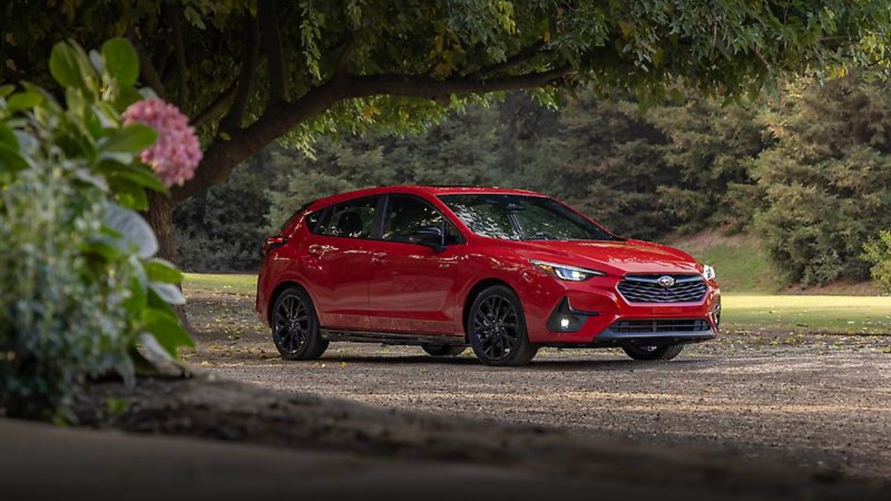 A red 2024 Subaru Impreza in the forest.