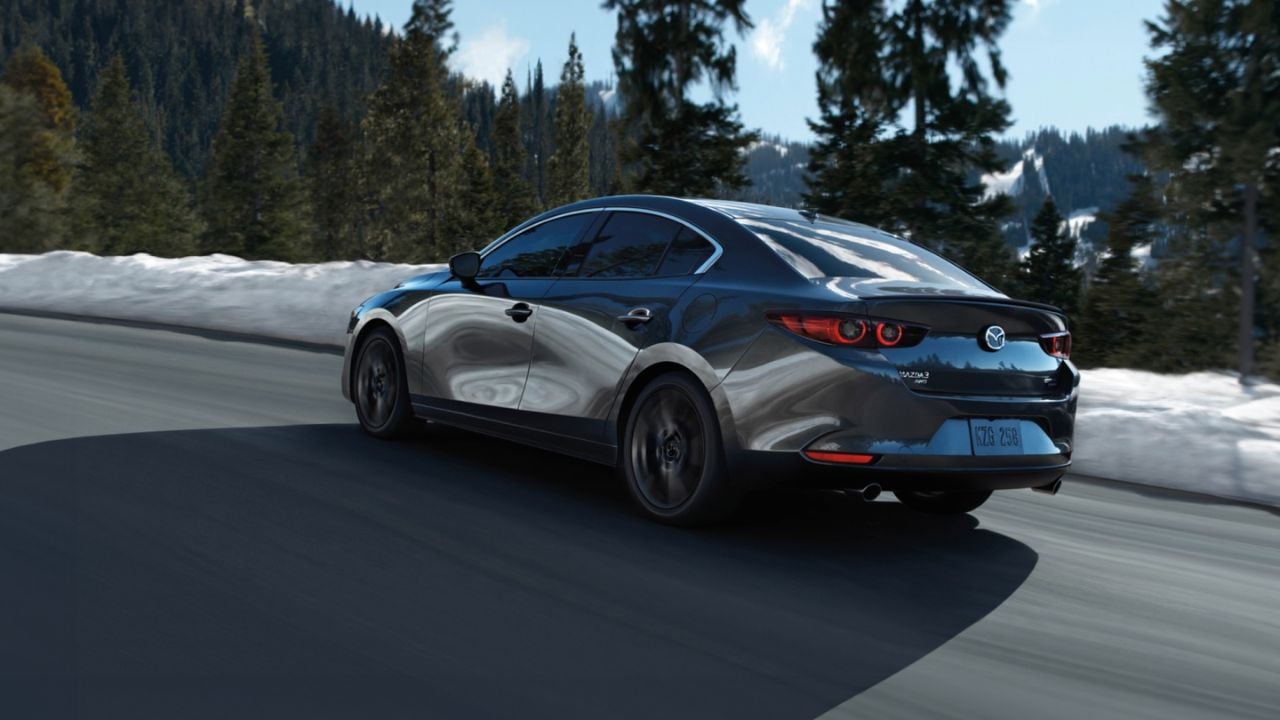 A gray 2025 Mazda3 Sedan in the mountains in winter.