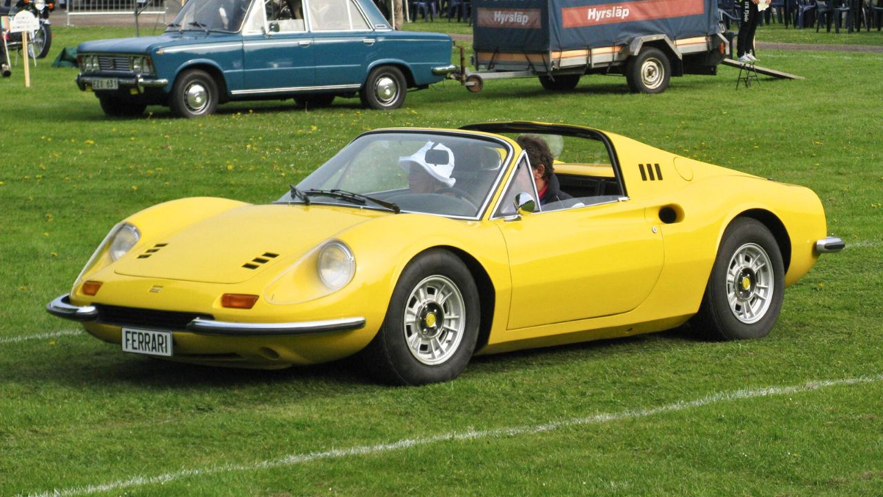 Yellow Ferrari Dino 246 GTS Parked On Field With Roof Down Front 3/ View