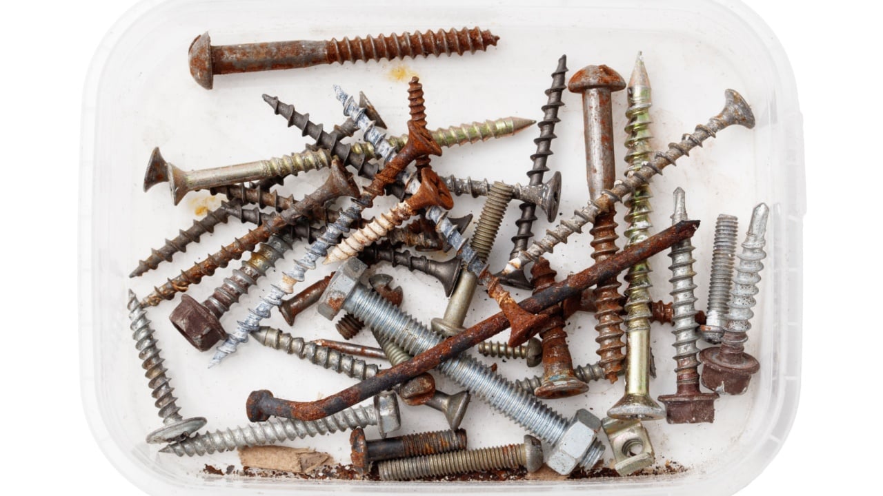 A container of rusty screws and nails