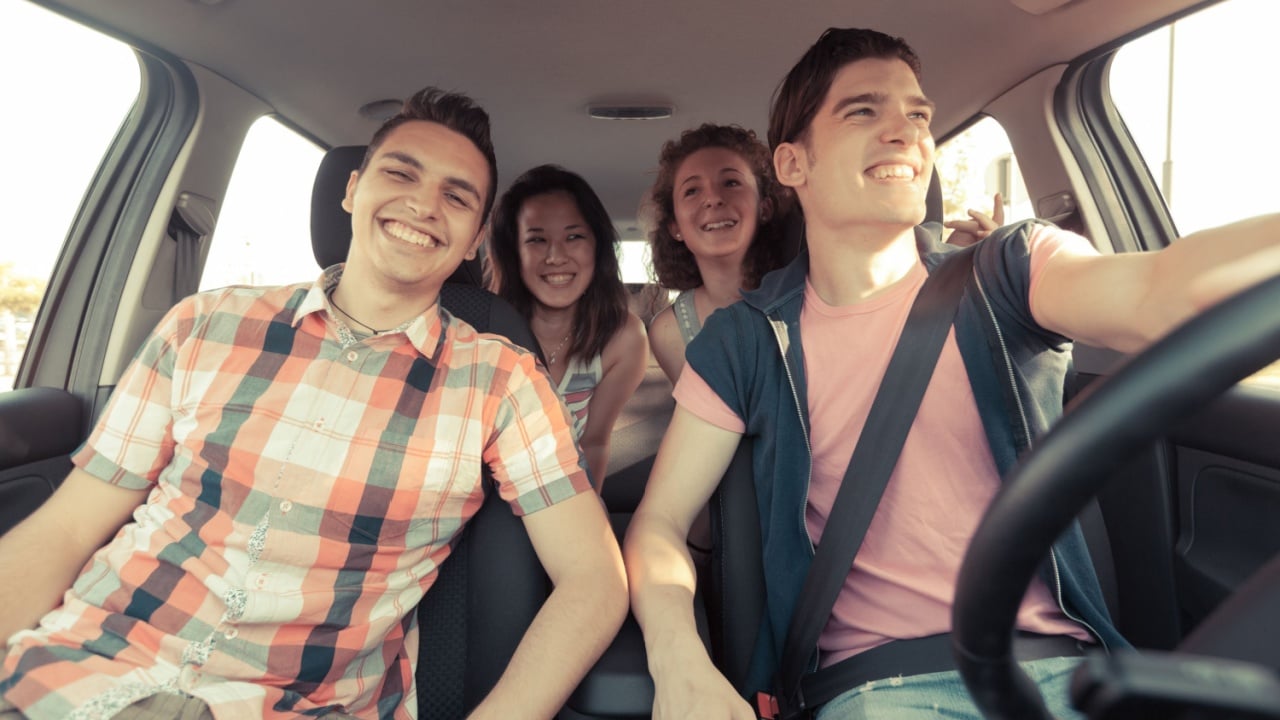 A group of friends in a car enjoying a road trip