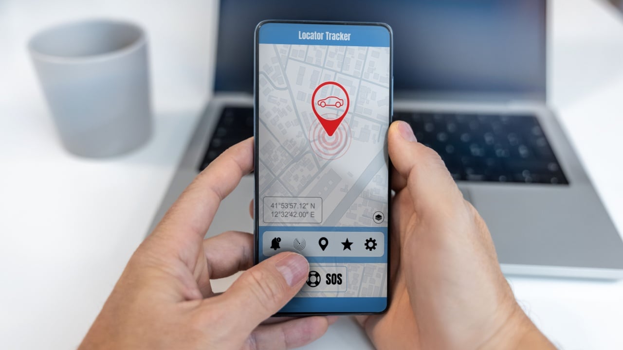A parent using a smartphone app to keep track of their child's car location