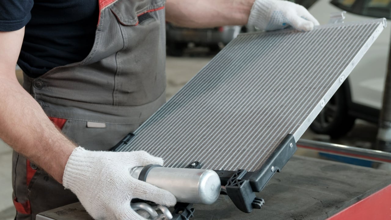 Car spare parts. An auto mechanic holds a new radiator.Checking and monitoring the serviceability and integrity of the radiator before replacing the defective one.