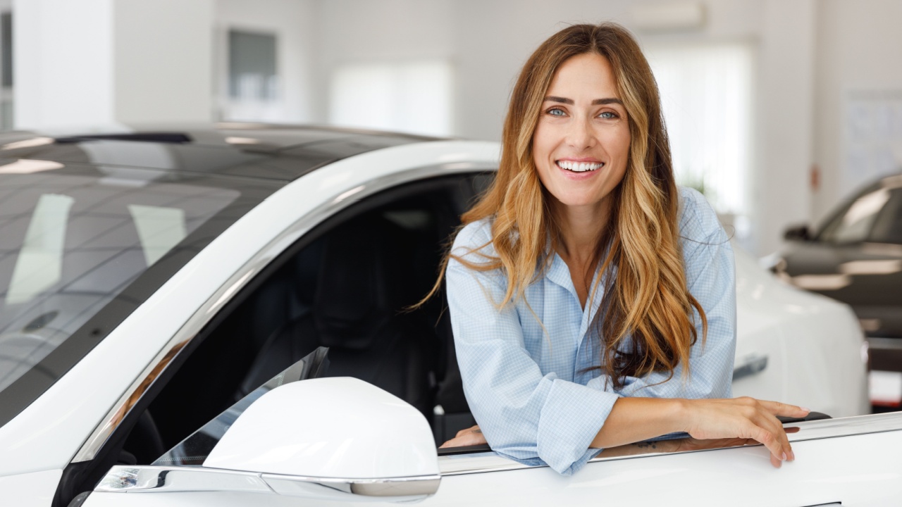 Happy woman who has just purchased traded in a car