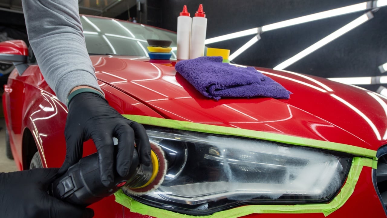 Headlight polishing. Adhesive tape on car headlights. Detailing car outside.