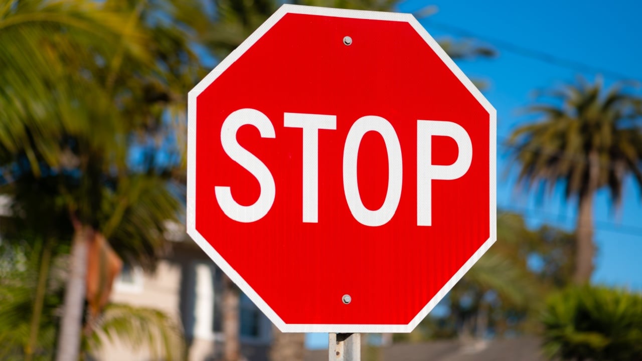 Red and white stop sign on a side road