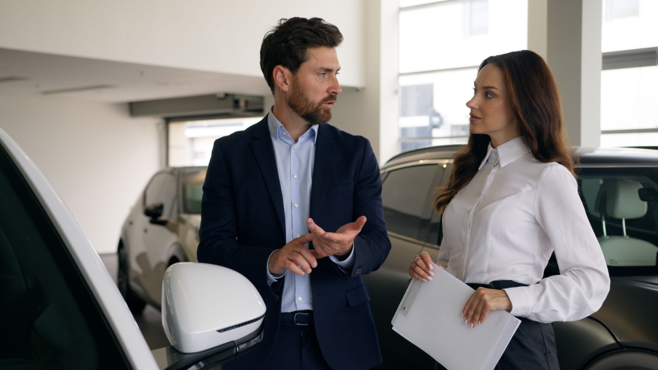 Two people talking in automobile showroom