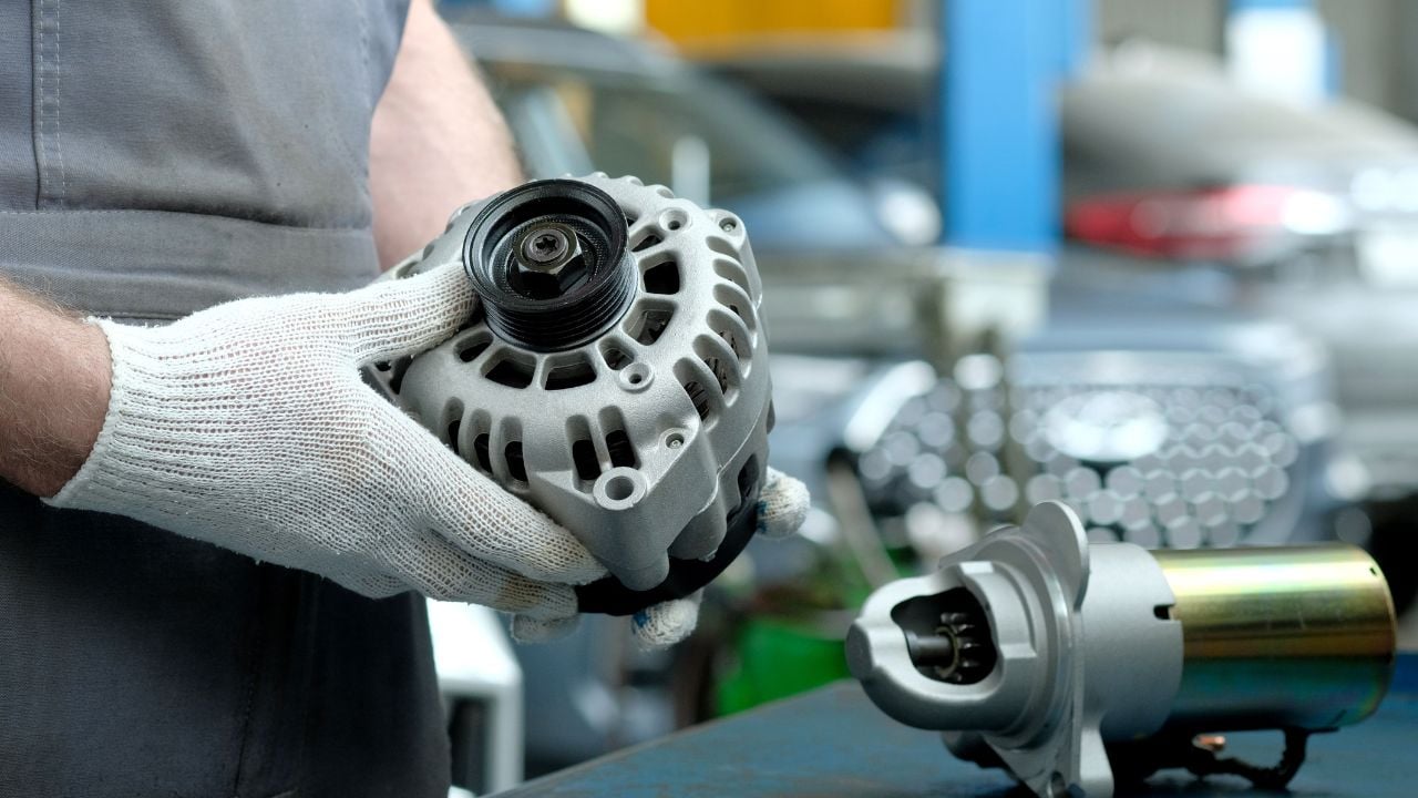 Repair and maintenance in a car service. An auto mechanic inspects the technical condition of a new car generator and starter.