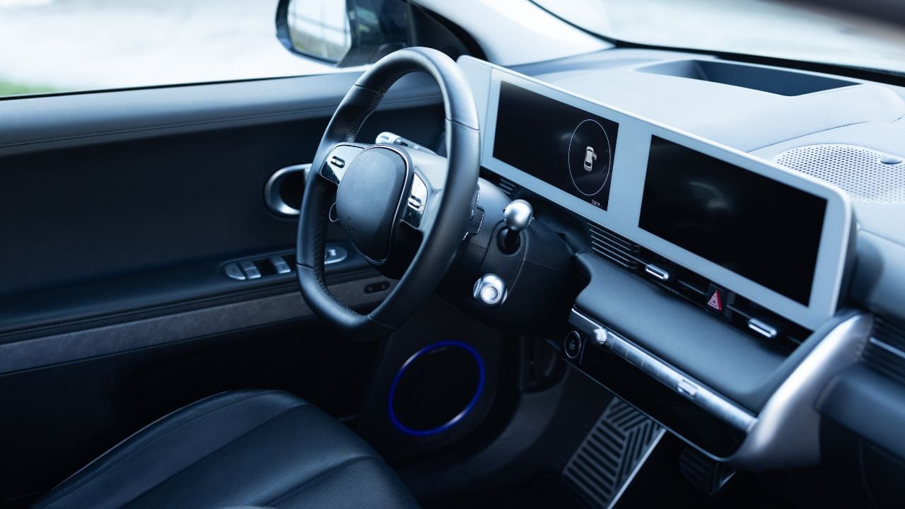 Prestige electric car. Inside car interior with front leather seats, steering wheel, windows, console, gear shift, electric buttons, digital speedometer. Luxury car interior. Car detailing series.