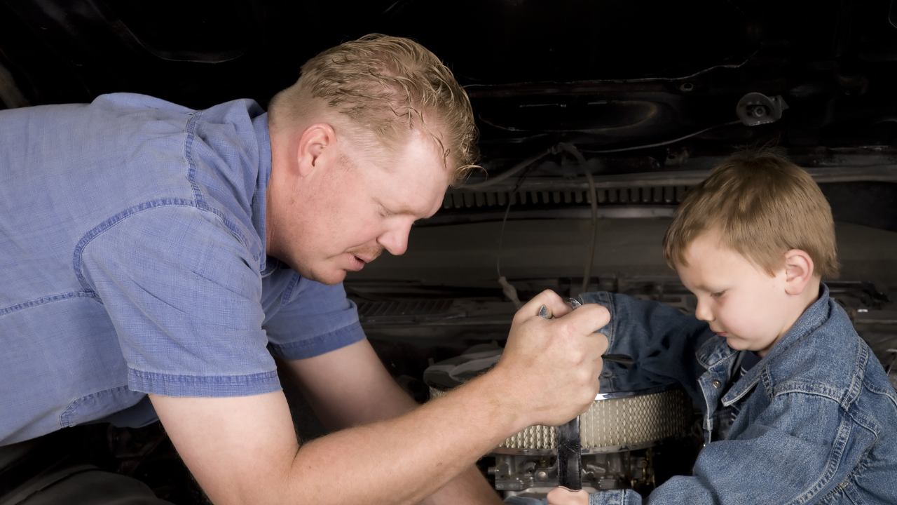 Man working on a car with his son