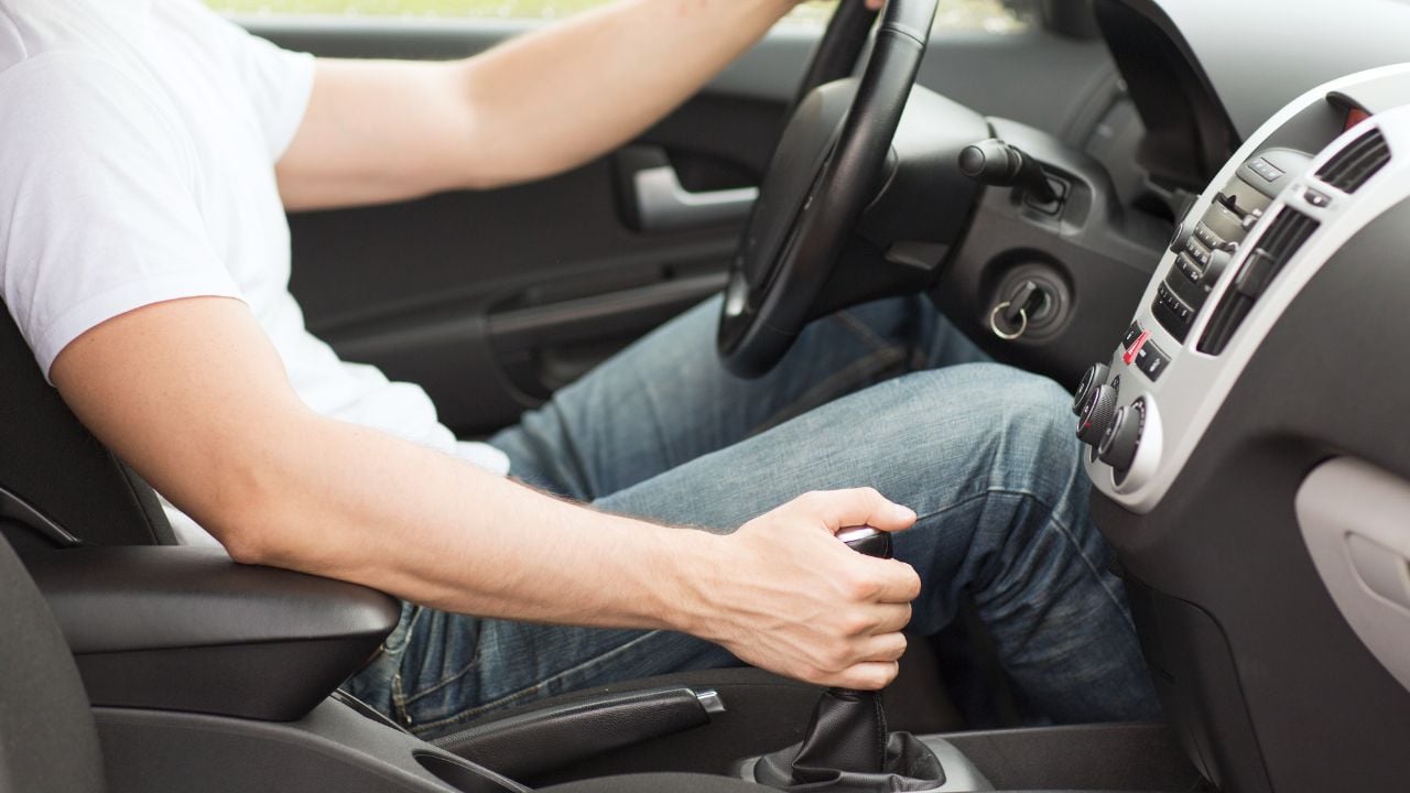 transportation and vehicle concept - man shifting the gear on car manual gearbox