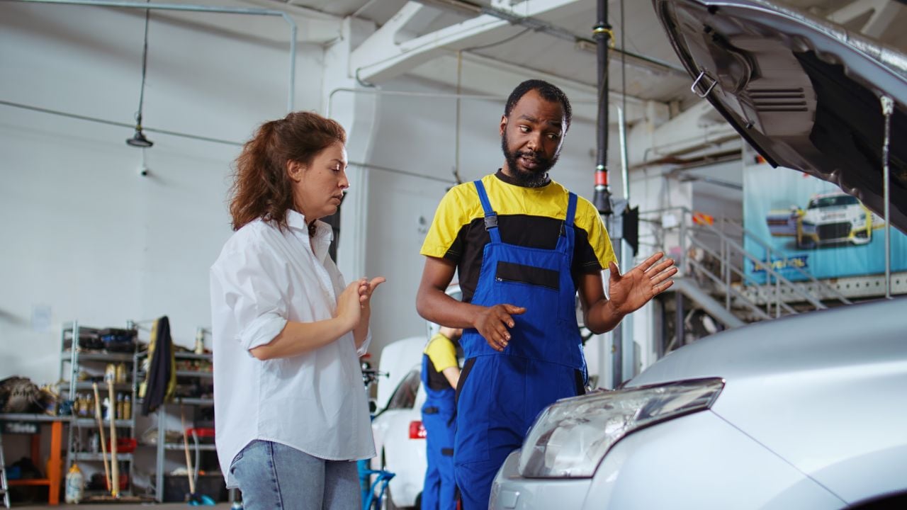 mechanic explaining car repair to customer garage