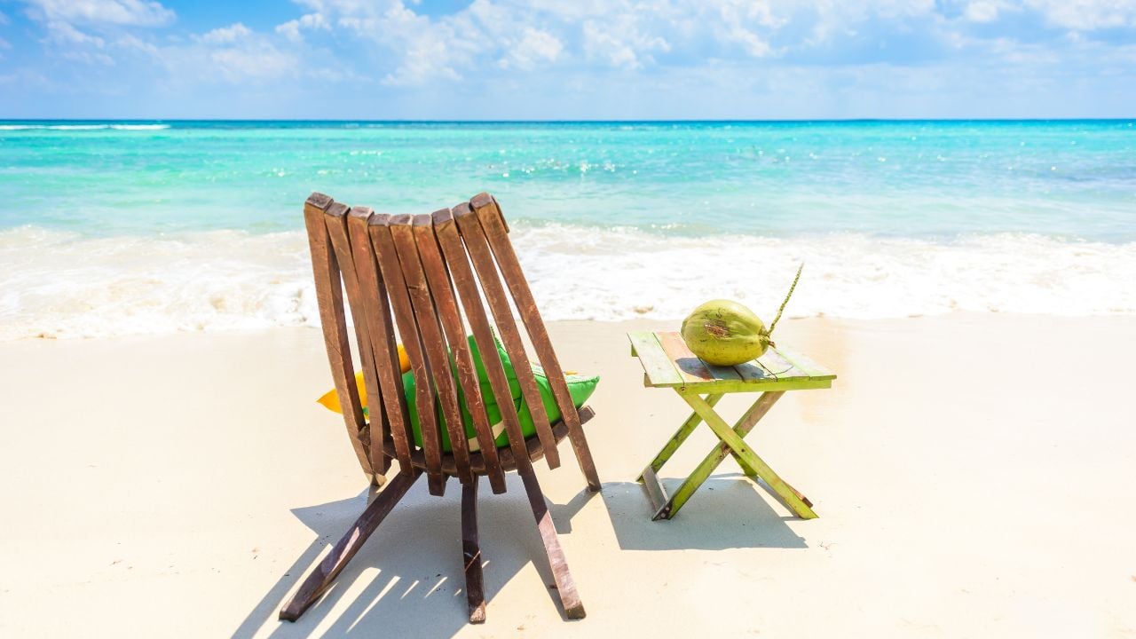 Playa del Carmen - relaxing on chair at paradise beach and city at caribbean coast of Quintana Roo, Mexico