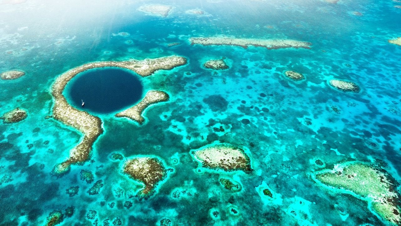 Aerial panoramic view of The Great Blue Hole - Detail of Belize coral reef from airplane excursion - Wanderlust and travel concept with nature wonders on azure vivid filter