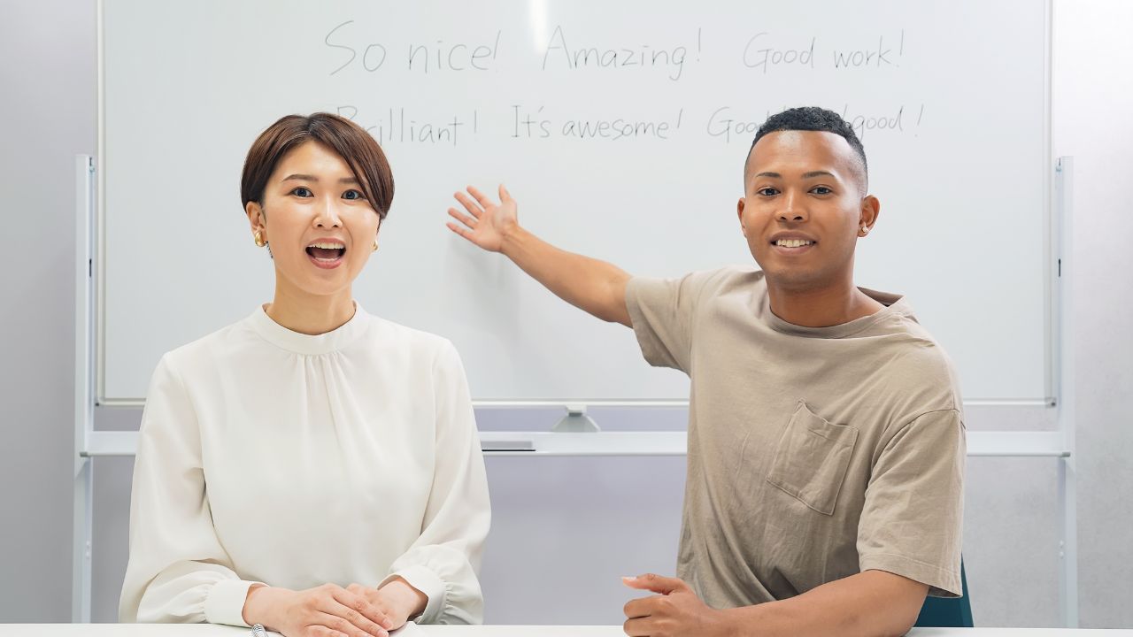 A black man and a Japanese woman teaching in a classroom