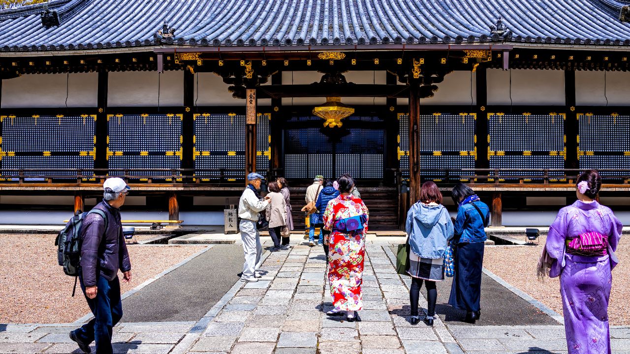 Kyoto, Japan - April 10, 2019: Ninna-ji temple building architecture entrance with people walking in spring wearing kimono costume