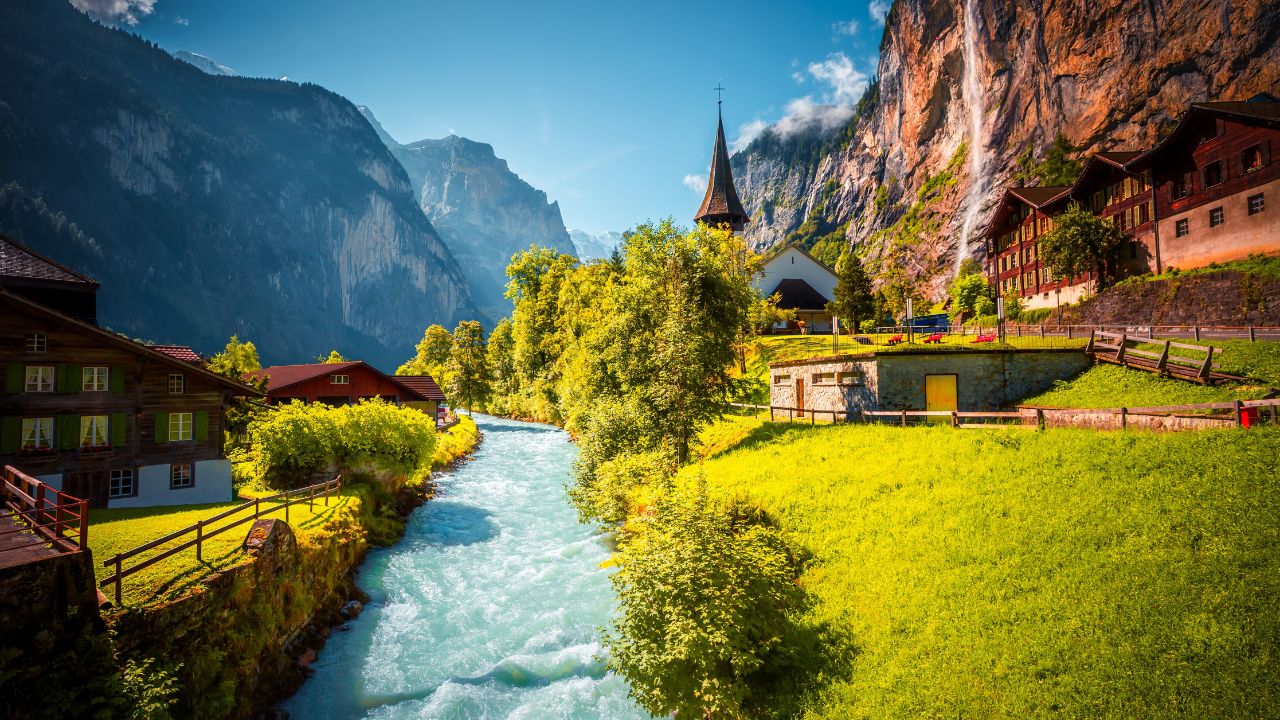 Charming alpine village in the Lauterbrunnen valley on a sunny day. Location place Bernese Alps, Switzerland, Europe. Tourist attraction. Image of harmony and tranquil. Discovery the beauty of earth.