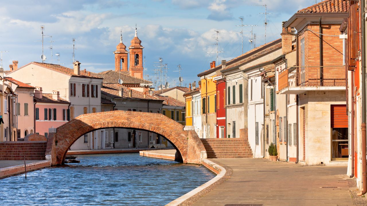 Comacchio (Ferrara, Emilia Romagna, Italy). Canal with bridge and colorful houses.