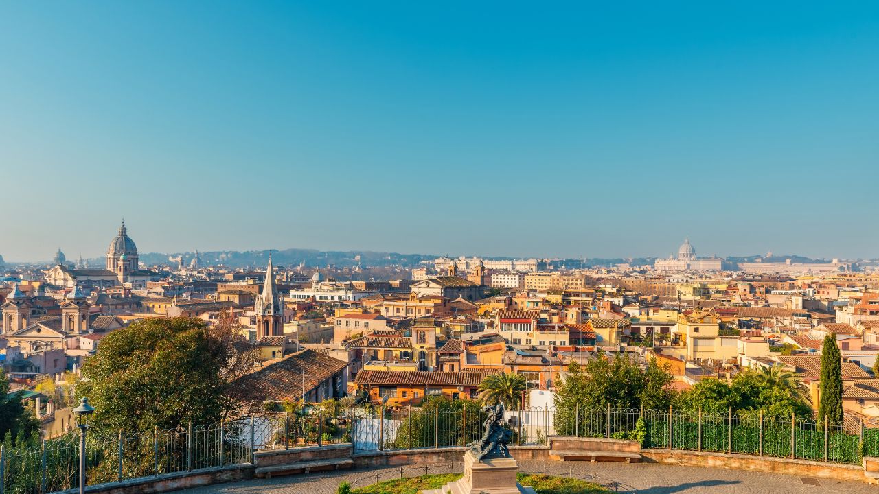 Panoramic view of Rome cityscape with domes, rooftops, Pincio Terrace and historic buildings under soft sunlight at sunrise, viewed from Pincian hill, Italy. Popular travel and touristic destination