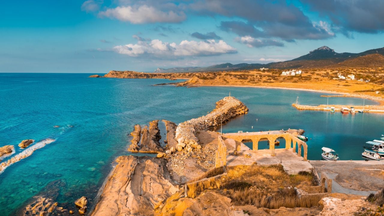 Small port in Famagusta Northern Cyprus at dusk, Mediterranean sea and ruins on the shore coast side, this is a safe area for travel and tourists at the moment of taking the photo