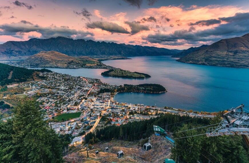 Aerial view of Beautiful sunset sky over illuminated Queenstown with Lake Wakatipu and Skyline Gondola at New Zealand