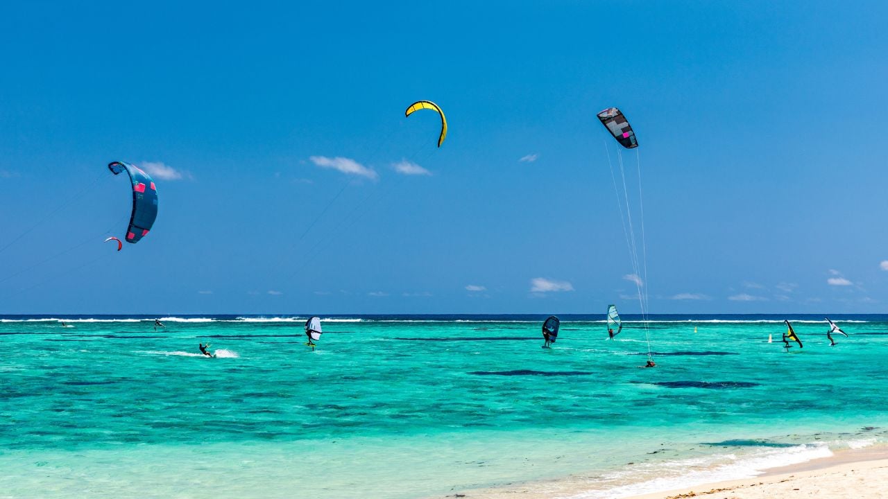 Kite surfers in the waters of Indian Ocean, Mauritius. Kite surfing in the clear waters of the Indian Ocean in Le Morne beach, Mauritius. Best Kite surfing experience at Mauritius island.