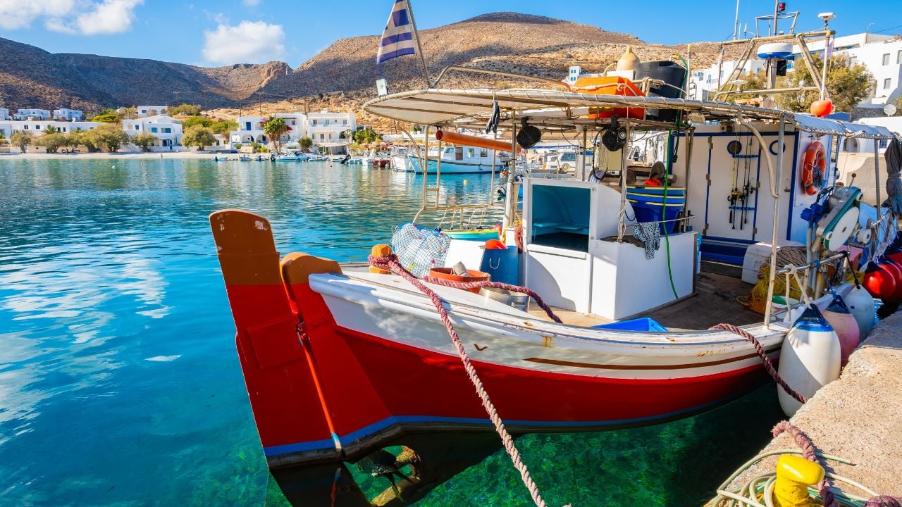 Traditional fishing boat anchoring in Karavostasis port, Folegandros island, Cyclades, Greece