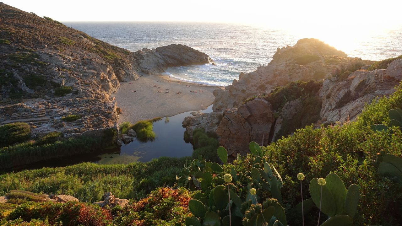 Sunset over beautiful wavy pebble beach of Nas where river flows in the sea in island of Ikaria, Aegean sea, Greece