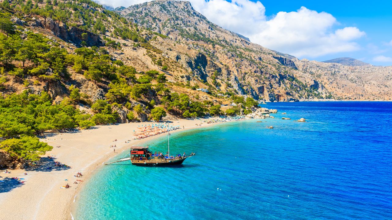 Sailing boat anchoring at beautiful Apella beach on Karpathos island, Greece