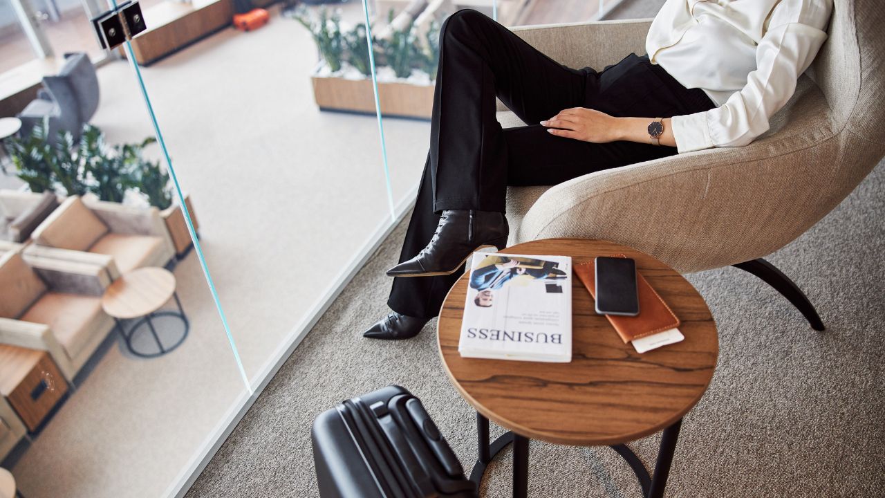 Stylish young woman resting in comfortable chair in departure lounge stock photo