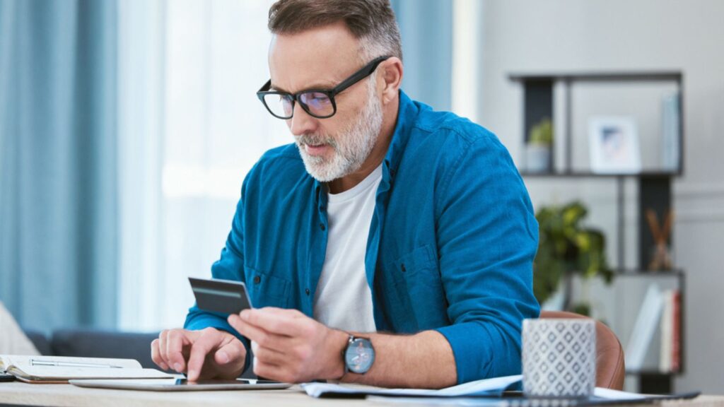 senior businessman using his digital tablet to make online card payments