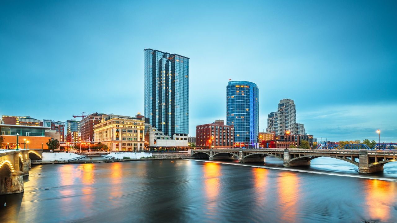 Grand Rapids, Michigan, USA downtown skyline on the Grand River at dusk.