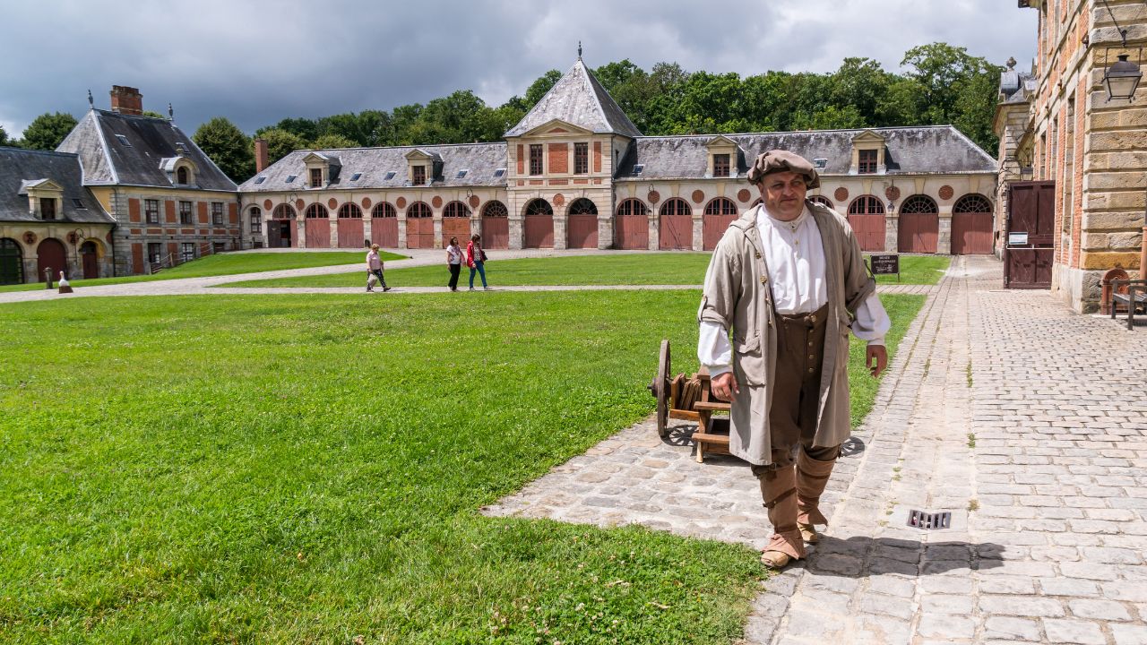 Chateau Vaux-le-Vicomte, Maincy, France - June 18, 2018: An actor in the costume of a 17th Century cattle herder greeting visitors in the castle's courtyard.