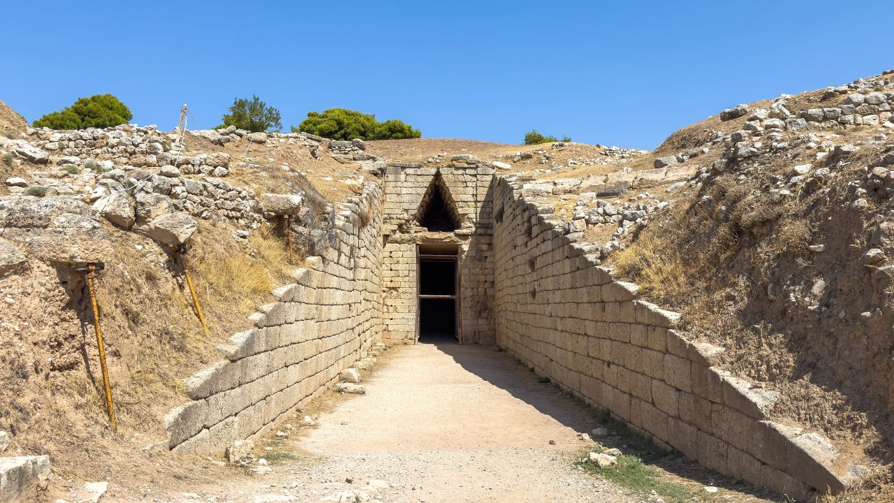 Tomb of Clytemnestra at the Mycenae archaeological site, blue sky, sunny day. Mycenaean tholos type tomb built in 1250 BC. Greece.