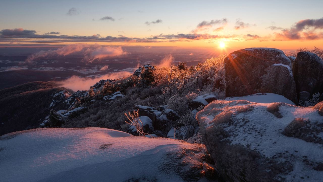 An absolute frigid and windy sunrise atop Old Rag Mountain looking across the icy rock scramble in Shenandoah National Park, Virginia.