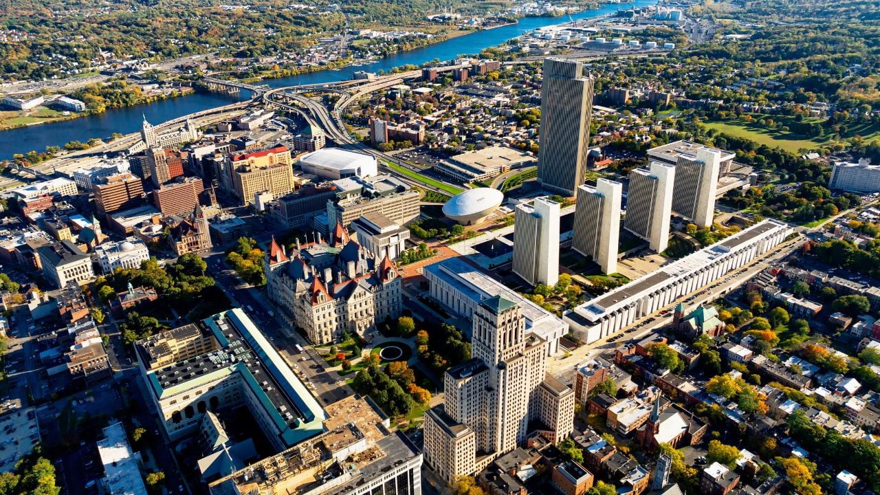 Albany cityscape with autumn foliage. The vibrant autumn colors surround Albany, highlighting its iconic skyline along the Hudson River and lush parklands.