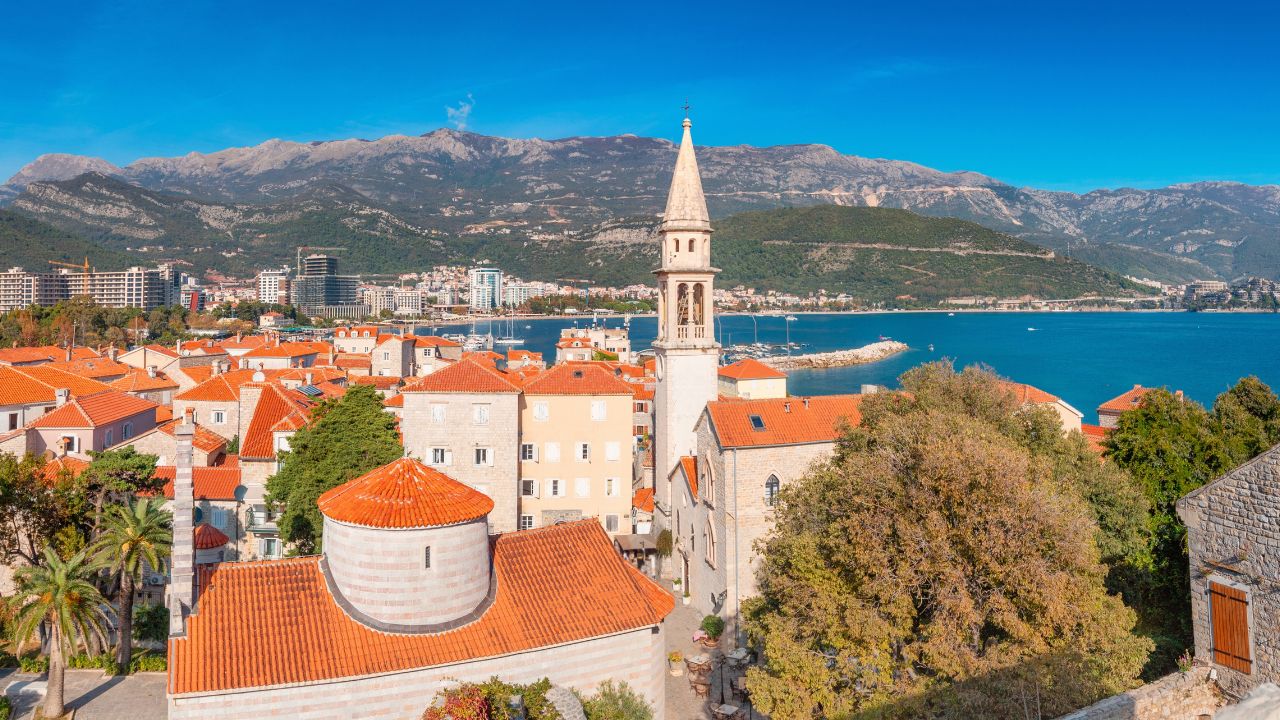 Picturesque cityscape of Budva, Montenegro, showcasing its historic architecture, vibrant red roofs, and stunning coastal scenery