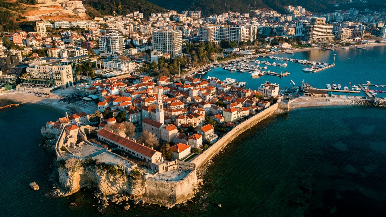 Aerial view of the old town Budva, city is surrounded by mountains. Selective focus on Montenegro. Budva with red tile roofs and high-rise buildings. Adriatic Sea View from above.