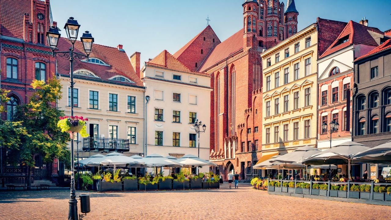 Colorful summer cityscape of Torun town, Poland. Splendid morning view of Church of the Assumption of the Blessed Virgin Mary and Blessed Father Stefan Wincenty Frelichowski on background.